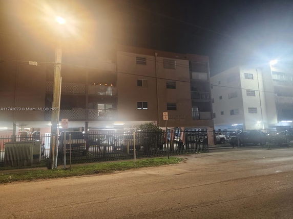 Front view of a multi-story apartment building at night.
