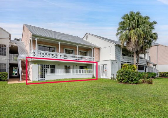 Front view of a two-story house with a balcony and external staircase.