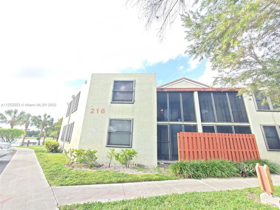 Front view of a two-story residential building with screened balconies.