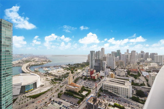 Aerial view of a cityscape with high-rise buildings and a waterfront.