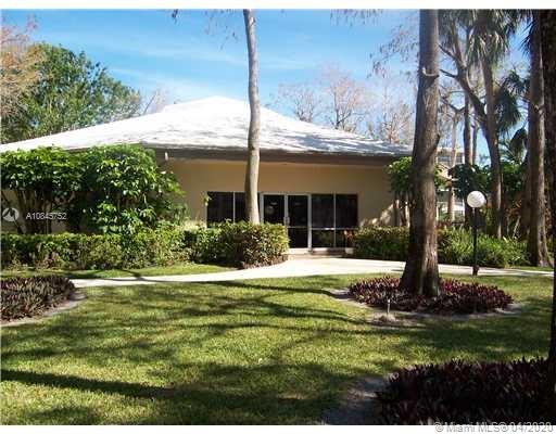 Front view of a single-story building with a sloped roof and large windows.