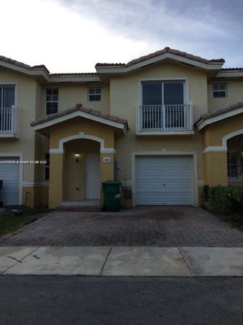 Front view of a two-story house with a single garage and balcony.