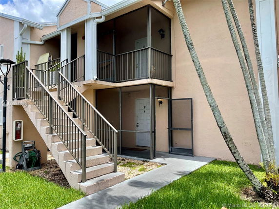Front view of a two-story building with a staircase leading to an upper level.