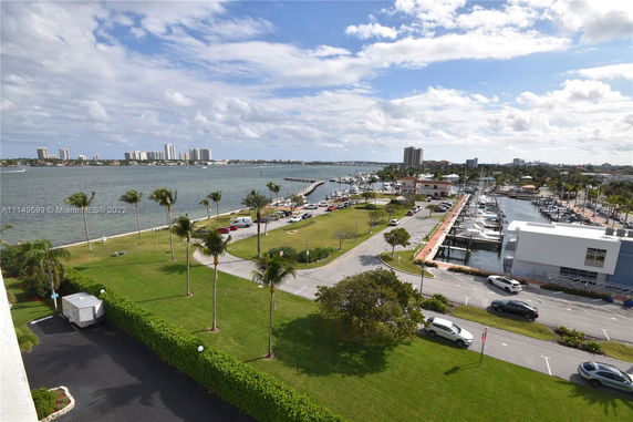 Wide view of a waterfront area with a marina and buildings in the distance.