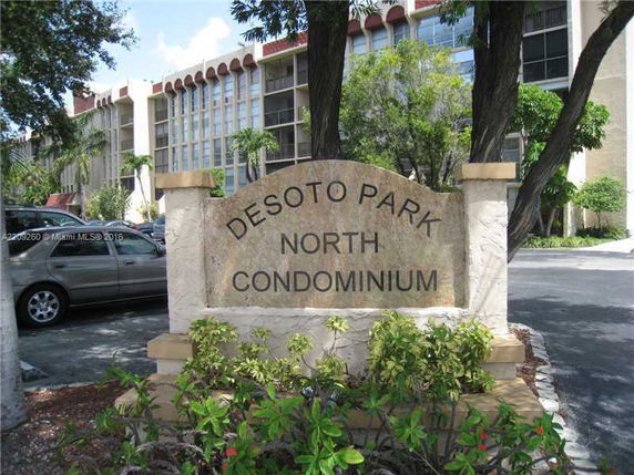 Front view of a condominium building with a sign reading 'DESOTO PARK NORTH CONDOMINIUM'.