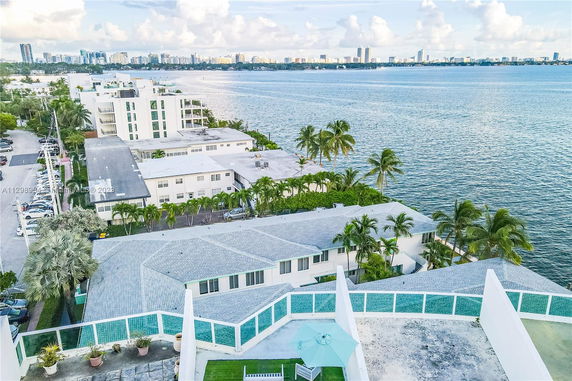 Rooftop with a seating area and a view of distant buildings across the water.