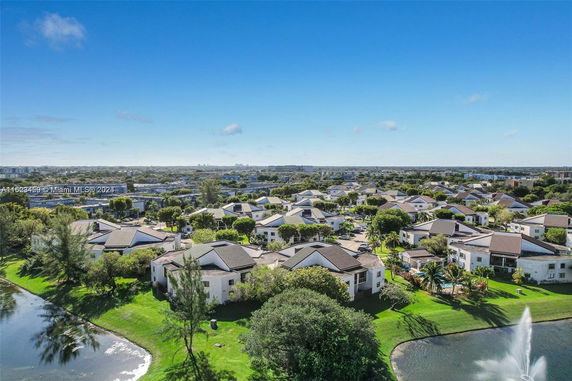 Aerial view of a residential neighborhood with houses and a lake.