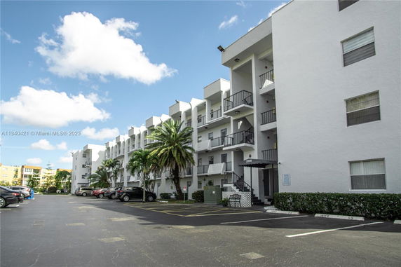 Front view of a multi-story apartment building with balconies.