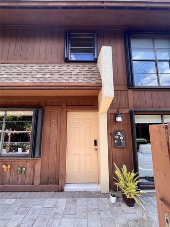 Front view of a two-story house with wooden siding and a beige front door.