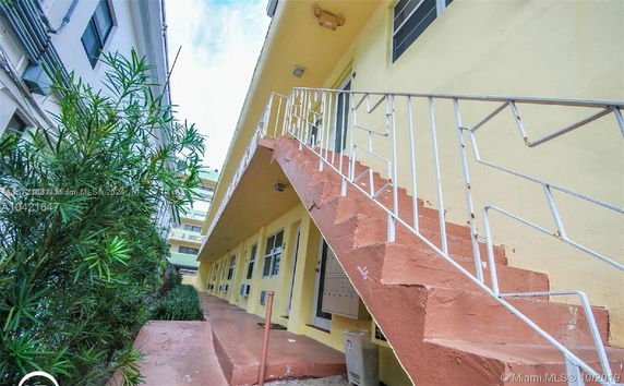 Side view of a multi-story building with an external staircase.