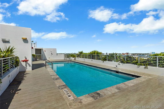 Outdoor rooftop swimming pool with surrounding views of the city.