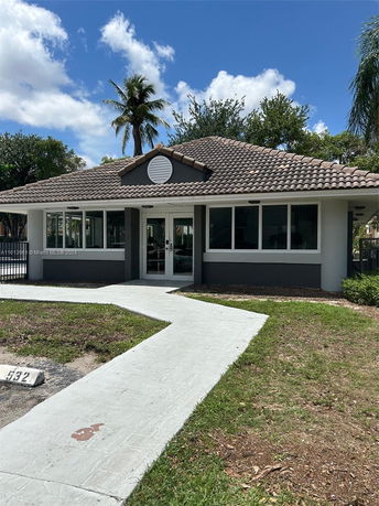 Front view of a single-story house with a tile roof and large windows.