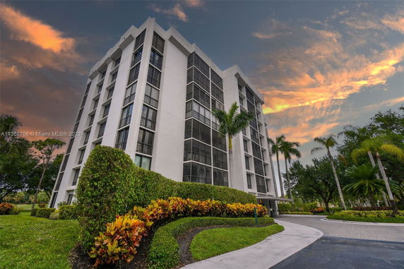 Front view of a multi-story apartment building with large windows.
