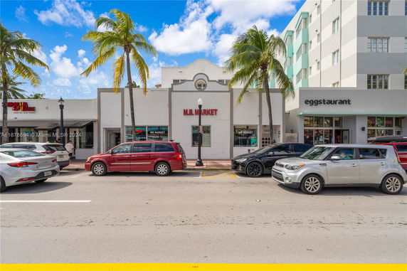 Front view of a building with storefronts, including MB Market.