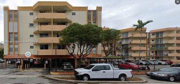 Front view of a multi-story condominium building with balconies.