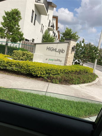 View of a multi-story building with balconies and a sign reading 'Highland at Park Central'.
