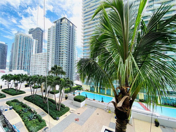 View of high-rise buildings with a pool and landscaped area in the foreground.