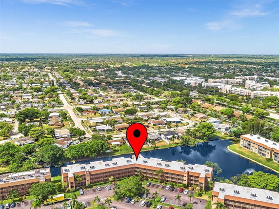 Aerial panoramic view of a suburban area with houses, roads, and water bodies.