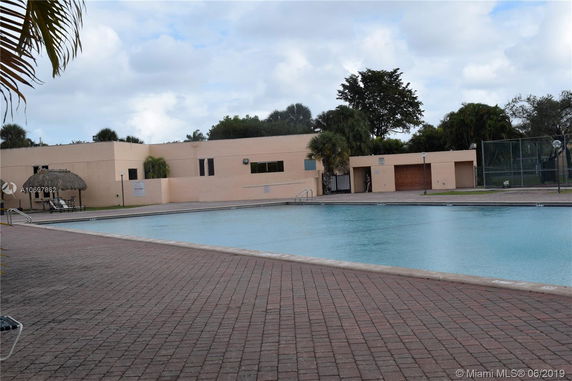 Outdoor swimming pool with a building in the background.