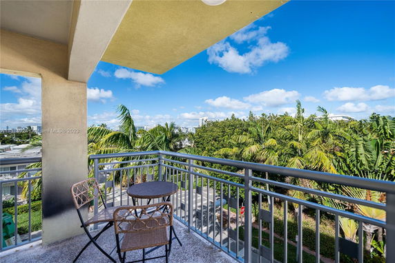Balcony view overlooking trees and distant buildings.