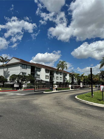 Front view of a multi-story residential building with a gated entrance.