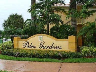 Front view of a building entrance with a sign that reads 'Palm Gardens'.