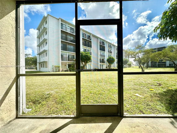 View through a mesh screen of a multi-story residential building with balconies.