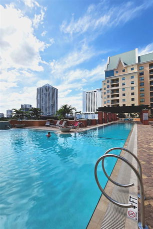 Outdoor swimming pool with surrounding buildings visible.