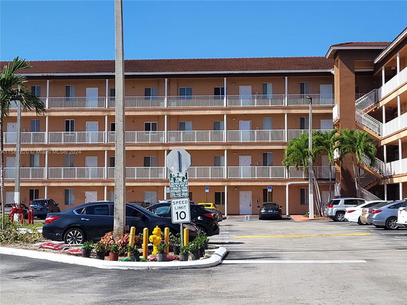 Front view of a multi-story apartment building with balconies.
