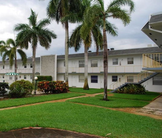 Front view of a two-story apartment building with exterior staircases and balconies.