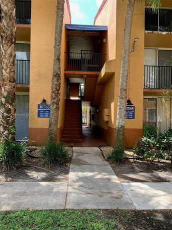 Front view of a multi-story building with external staircase leading to upper levels.
