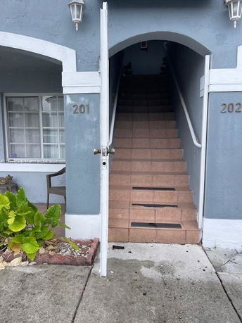 Front view of a stairway entrance to a building with blue exterior walls.