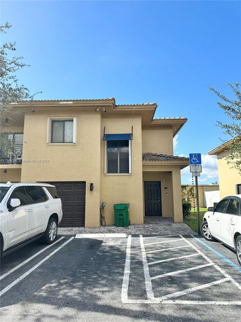 Front view of a two-story house with an attached garage and a blue awning above the entrance.
