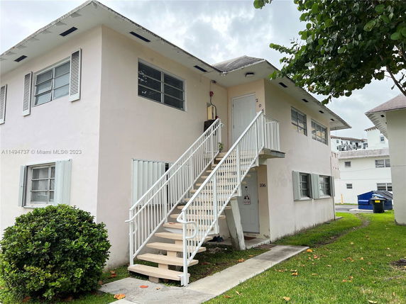 Front view of a two-story building with external staircase.