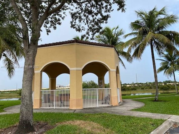 Front view of a small, open pavilion with arches and a tiled roof.