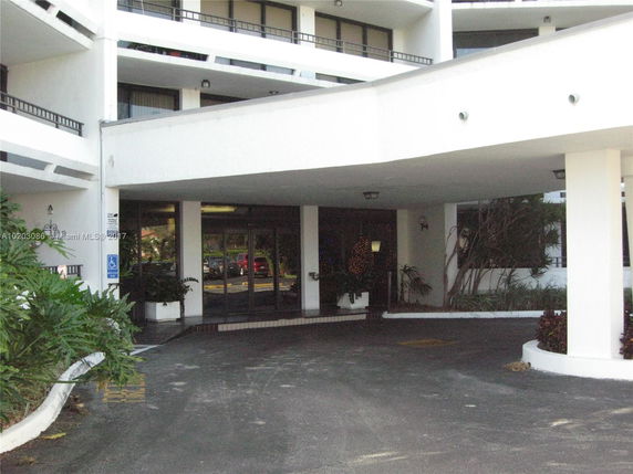 Entrance of a multi-story building with a covered driveway.
