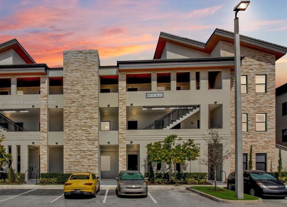 Front view of a multi-story building with stone detailing and exterior staircases.