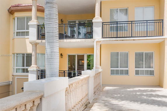 View of a multi-story building with balconies and large windows.