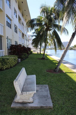 Side view of a multi-story building with palm trees and waterway.