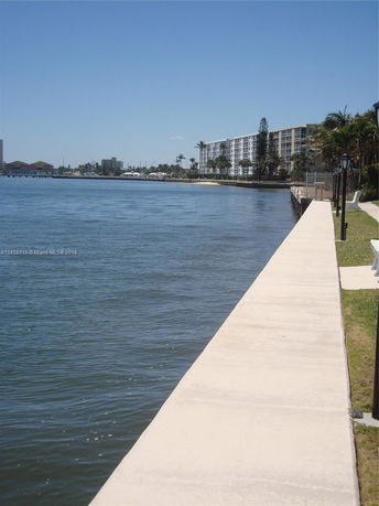 View of a waterfront area with a multi-story building along the shoreline.