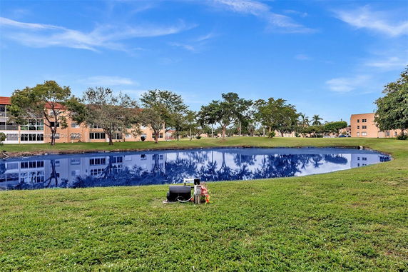 Scenic view of buildings and trees reflected in a pond.