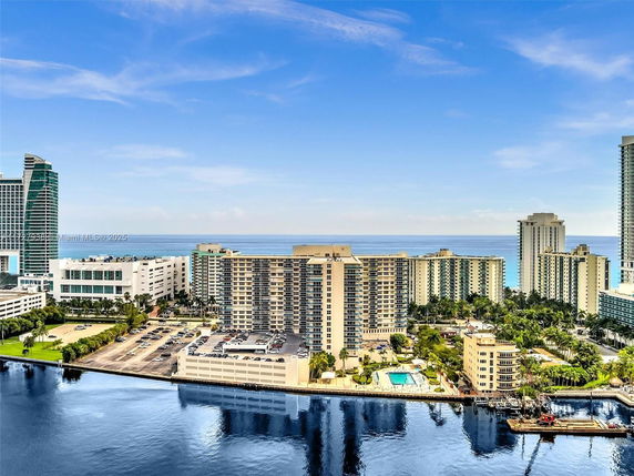 Wide angle view of buildings near the water with a visible shoreline in the background.