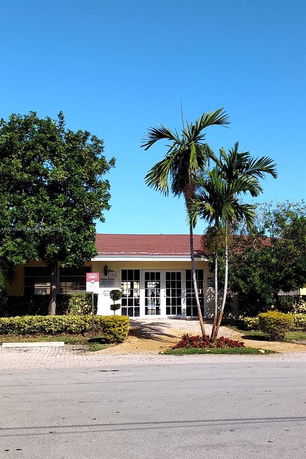 Front view of a single-story house with a red roof and large glass doors.