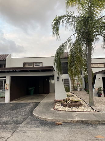 Front view of a two-story house with a covered parking area.