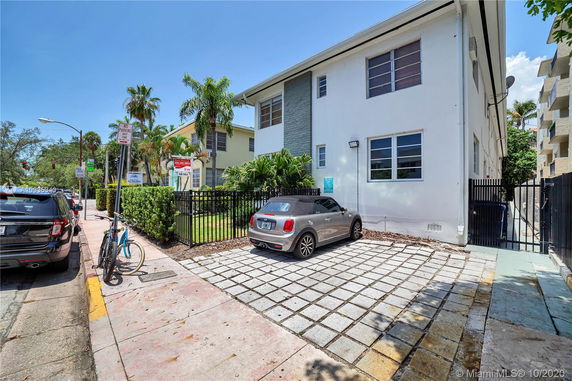 Outdoor parking area next to a white two-story building.