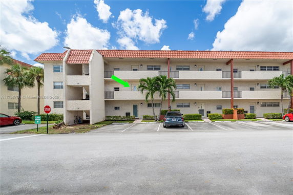 Front view of a three-story residential building with parking spaces.