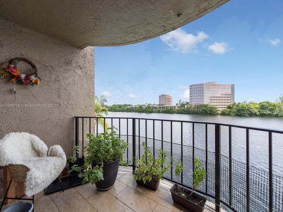 Balcony view overlooking a body of water with buildings in the distance.