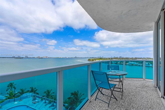 Balcony with a view of the ocean and distant city skyline.