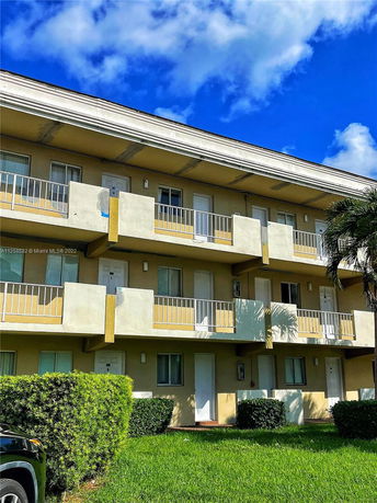 Front view of a three-story apartment building with balconies.