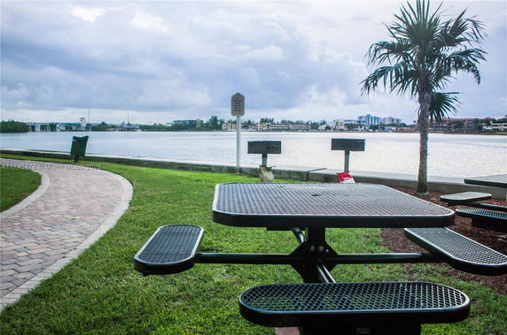 View of a park area with picnic tables near a body of water.